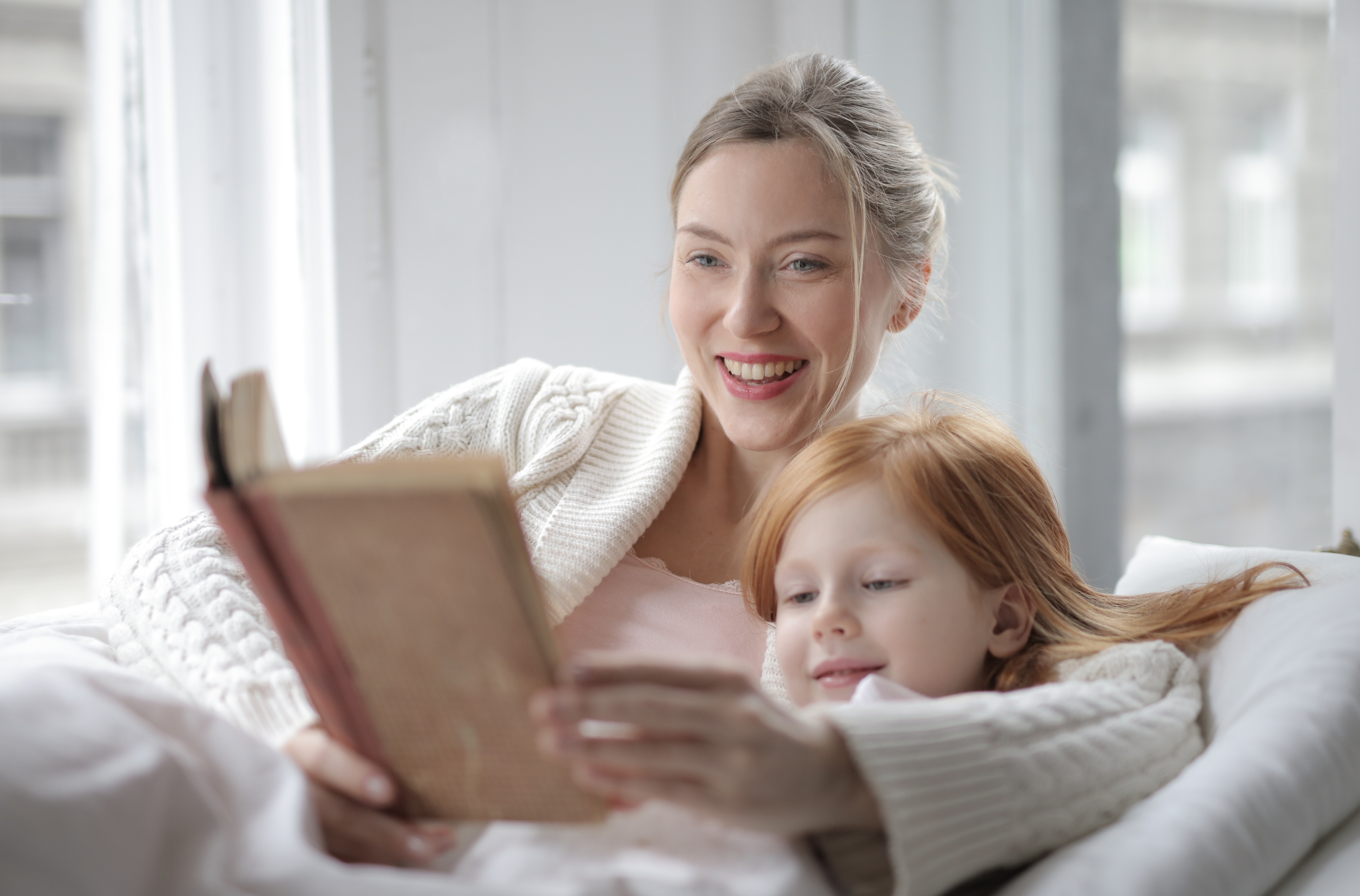 Photo of woman reading with child